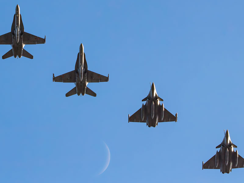 Formación en vuelo de Rafale y F-18 con la luna al fondo