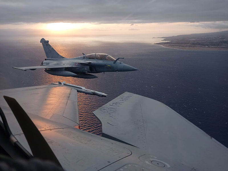 Formación en vuelo de Rafale y F-18 con la luna al fondo
